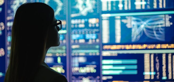The businesswoman in glasses standing near the display